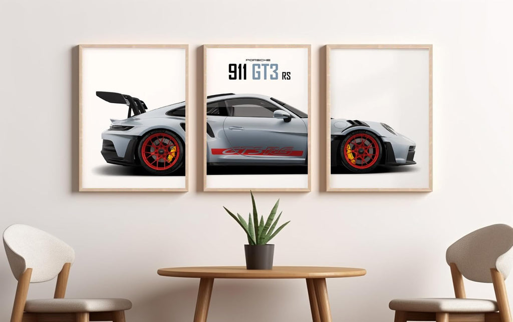 A three-panel framed wall art print set showing a silver Porsche 911 GT3 RS, displayed in a modern room setting above a wooden table with two chairs.