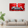 A three-panel canvas wall art print featuring a silver Porsche 911 GT3 RS on a bold red background, displayed in a modern living room setting above a beige sofa with a green potted plant.