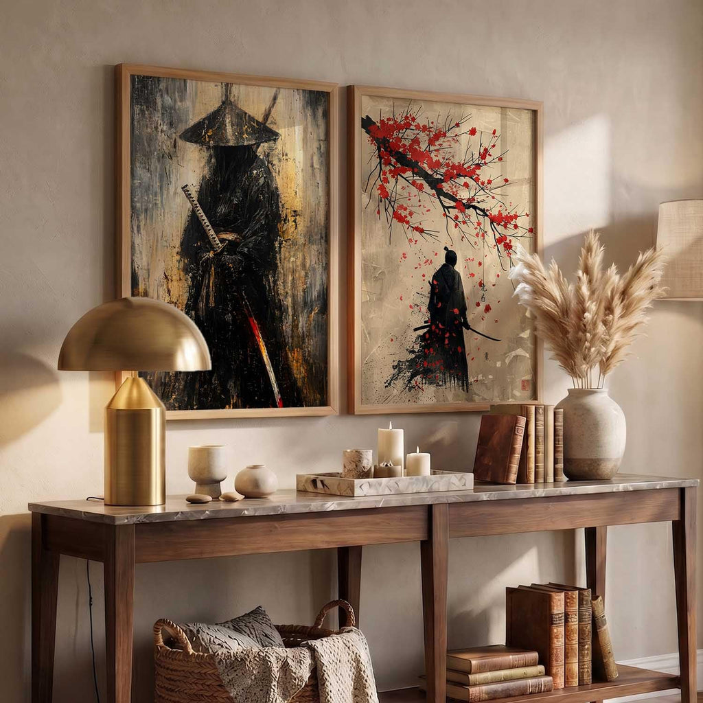 Two framed wall art prints displayed above a console table in a styled interior. The left print shows a dark samurai figure with a sword against a textured beige and black background.