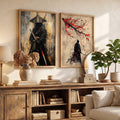 Two framed vertical art prints displayed side-by-side on a beige wall above a rustic wooden console table in a styled living room setting. The left print depicts a samurai warrior in black and gold, and the right print shows a samurai silhouette under red cherry blossoms.